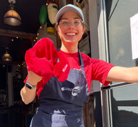 Rachel posing with a stuffed animal lobster toy and a luke's apron