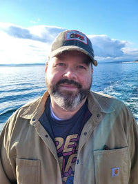 Clay posing for a picture in front of the ocean