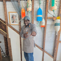 Johnnie Brown standing in front of a buoy wall at Luke's Lobster