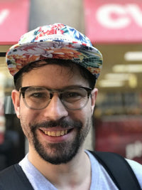 JP McIntyre; man smiling wearing glasses and a tropical hat