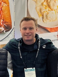 craig wearing a flannel smiling for a picture
