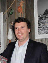 Garret wearing a suit jacket smiling for a photo