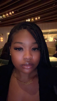 Kaiya with braided hair wearing a gold necklace in an indoor setting

