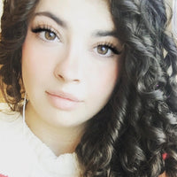 Woman with curly hair wearing a colorful sweater