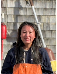 Miranda smiling in front of a wall lined with buoys