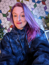 Michelle smiling for a selfie in front of a colorful backdrop