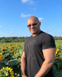 Federico Barona; standing in a sunflower field wearing a black shirt and sunglasses