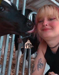 Courtney posing for a selfie with a cow