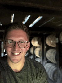 Owen smiling for a photo inside a wine cellar