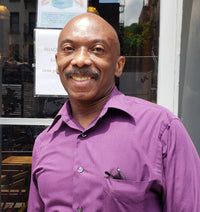 Darwin Lowe; man standing smiling with a purple dress shirt