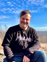 Will wearing a black Miami shirt smiling for a picture outside