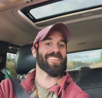 Eddie taking a selfie in the car while wearing a baseball hat and sweatshirt